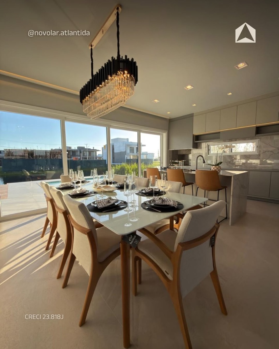 Sala de jantar com lustre de cristal e cozinha integrada